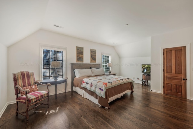 bedroom with vaulted ceiling, wood finished floors, visible vents, and baseboards