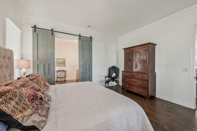 bedroom featuring a barn door, ornamental molding, baseboards, dark wood-style flooring, and visible vents