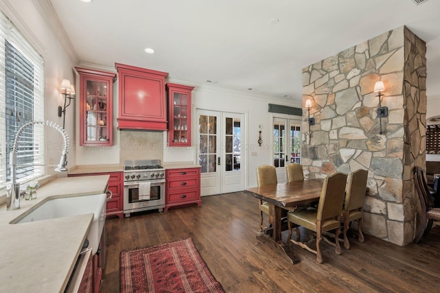 kitchen with high end stainless steel range, red cabinetry, a sink, and french doors