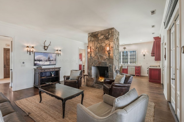 living room with dark wood finished floors, visible vents, crown molding, baseboards, and a fireplace