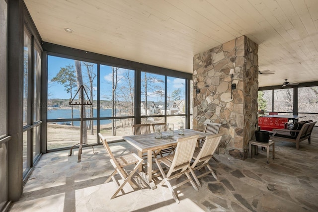sunroom / solarium with wooden ceiling, stone flooring, and a water view