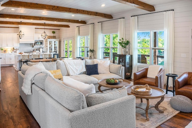 living room with wood walls, dark hardwood / wood-style flooring, and beamed ceiling