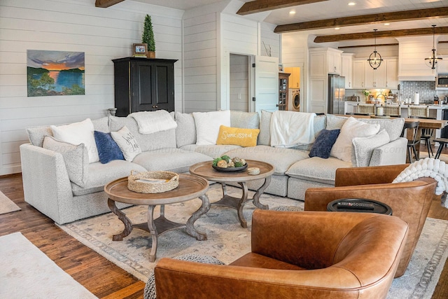 living room with wood walls, beamed ceiling, dark hardwood / wood-style floors, and washer / dryer