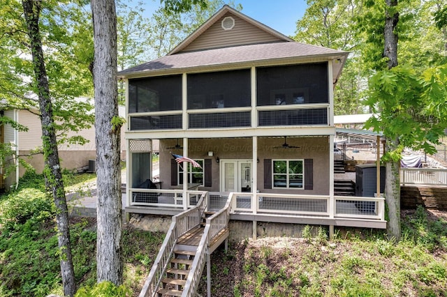 back of property featuring stairway, a shingled roof, and a sunroom