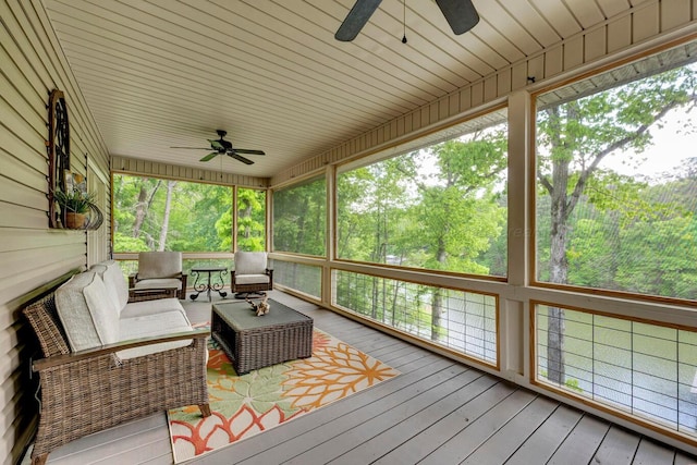 wooden deck with outdoor lounge area and a ceiling fan