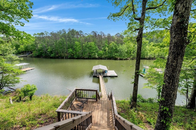view of dock featuring a water view and a forest view