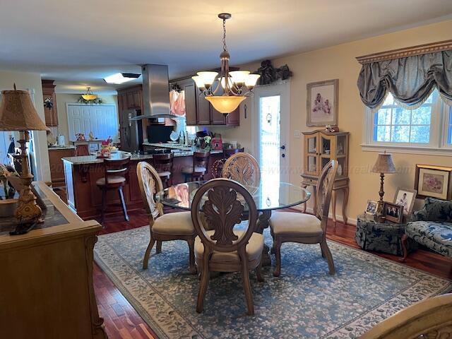 dining area with a chandelier and dark wood-type flooring