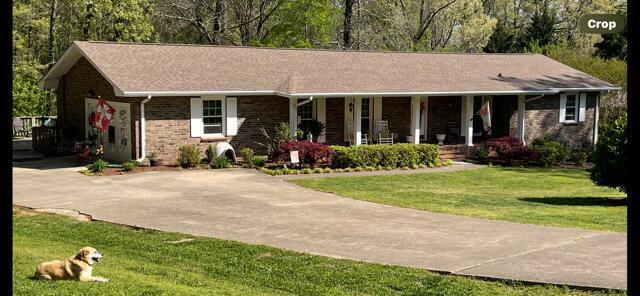 ranch-style home with a front lawn and a porch