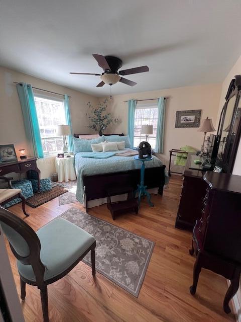 bedroom featuring light wood-style floors, ceiling fan, and multiple windows