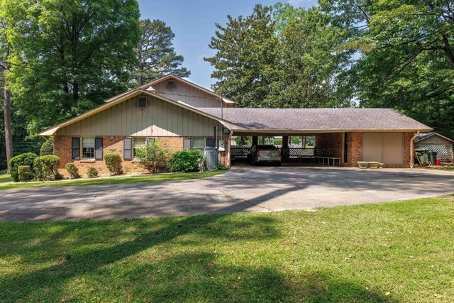 1004 Quarry Rd, Jasper, AL 35501 - ranch-style house with asphalt driveway, brick siding, an attached carport, and a front lawn
