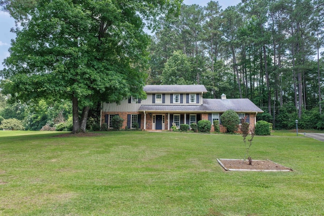 1004 Quarry Rd, Jasper, AL 35501 - view of front facade with covered porch, a front yard, brick siding, and a chimney