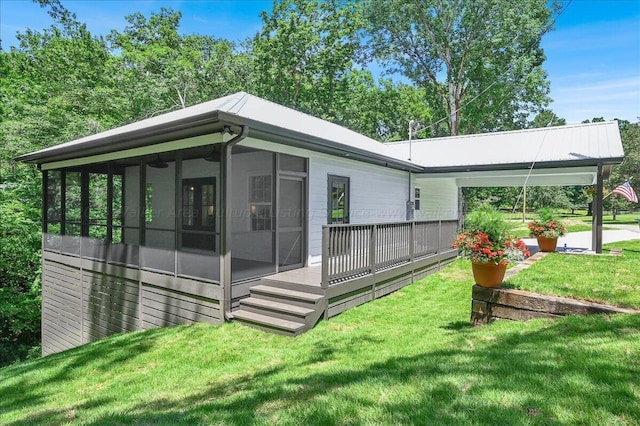 back of property with a yard and a sunroom