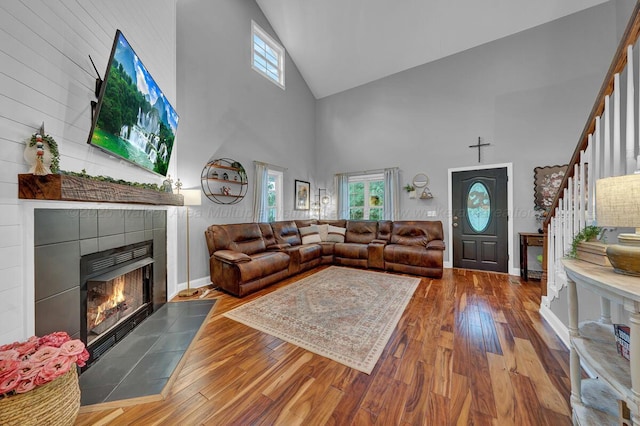 539 Hayfield Dr, Dora, AL 35062 - living area with high vaulted ceiling, stairs, a tile fireplace, healthy amount of natural light, and wood finished floors