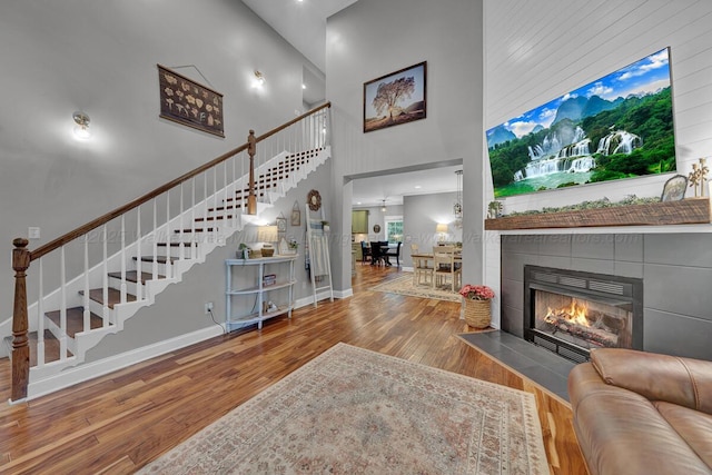 539 Hayfield Dr, Dora, AL 35062 - living room featuring a high ceiling, stairway, wood finished floors, and a tiled fireplace