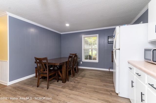 12 Dover Rd, Haleyville, AL 35565 - dining space featuring light wood finished floors, crown molding, a textured ceiling, and baseboards