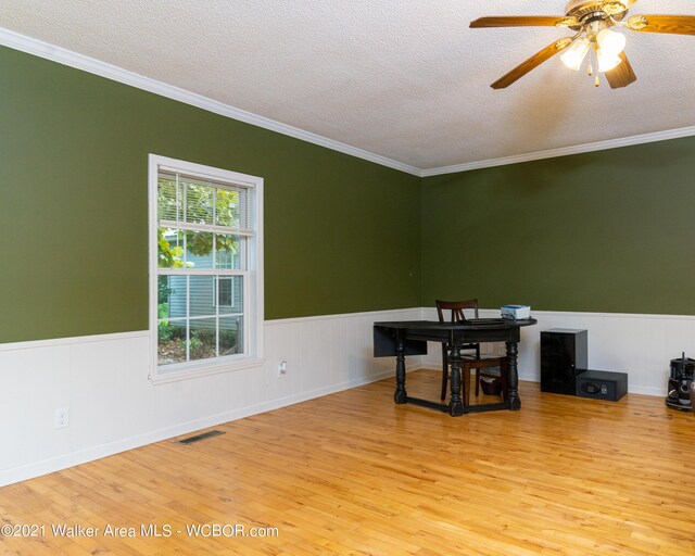 12 Dover Rd, Haleyville, AL 35565 - unfurnished dining area with a textured ceiling, a ceiling fan, a wainscoted wall, and wood finished floors