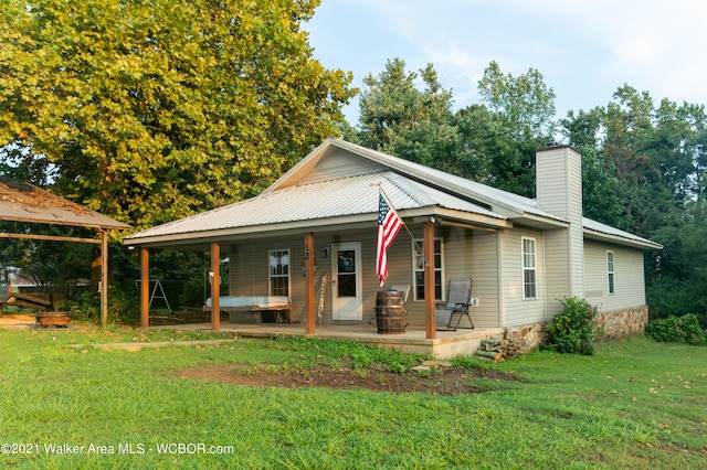 12 Dover Rd, Haleyville, AL 35565 - farmhouse-style home featuring a chimney, metal roof, and a front lawn