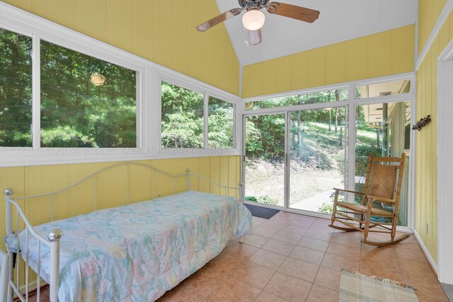 bedroom featuring multiple windows, lofted ceiling, tile patterned flooring, and a ceiling fan