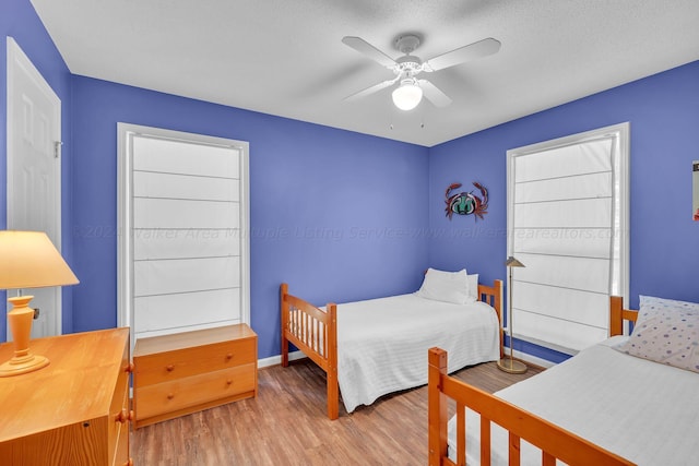 bedroom with baseboards, ceiling fan, and wood finished floors