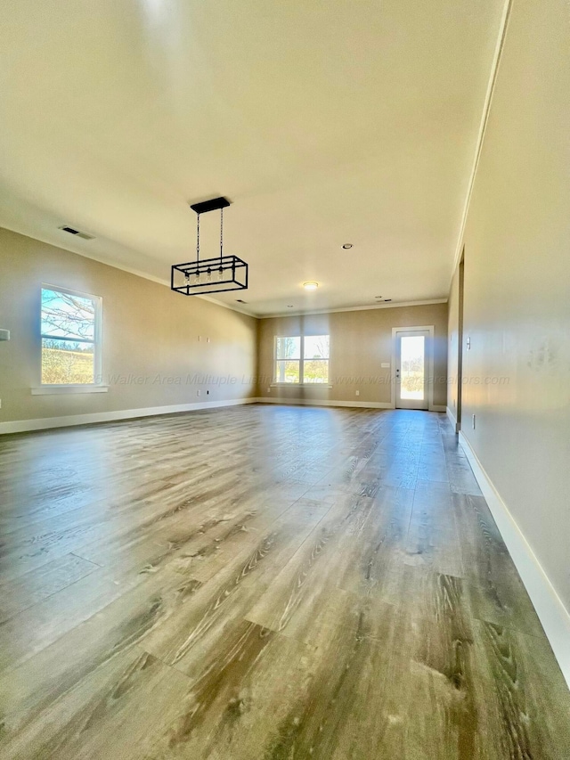 interior space with visible vents, baseboards, a healthy amount of sunlight, and wood finished floors