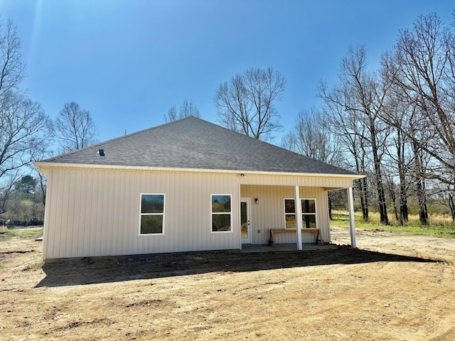 rear view of house with roof with shingles