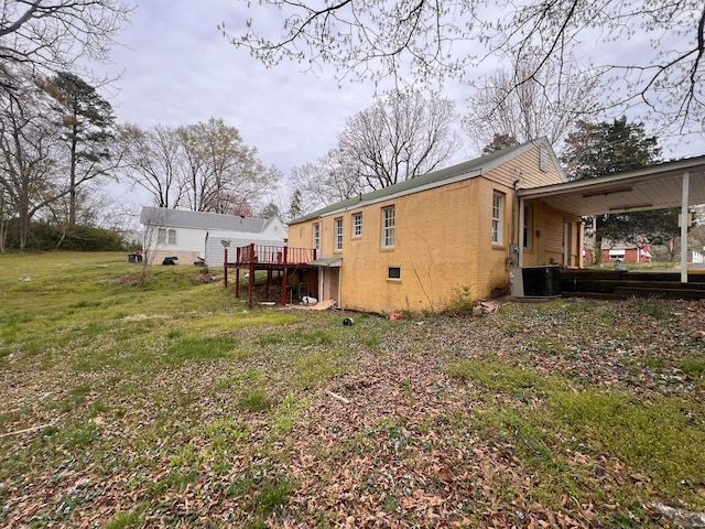 2514 15th Ave, Haleyville, AL 35565 - back of property with a deck, a yard, a chimney, brick siding, and cooling unit