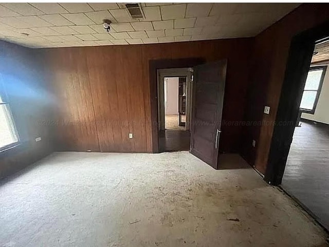 empty room with wood walls and concrete floors