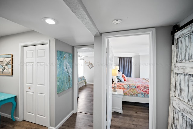 bedroom featuring baseboards, wood finished floors, and a closet