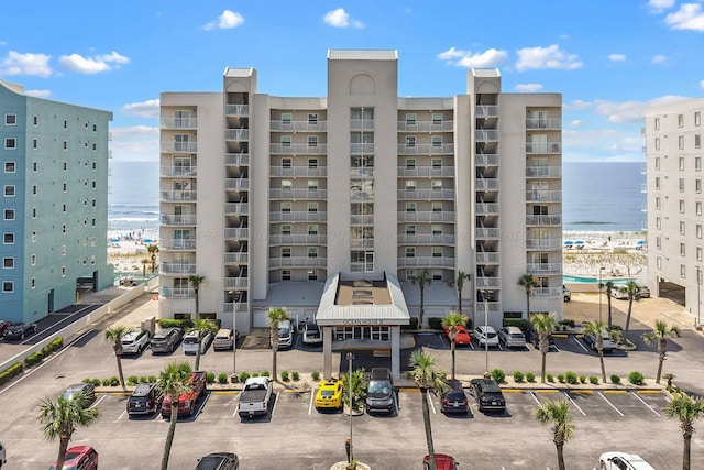 view of apartment building / complex featuring uncovered parking and a water view