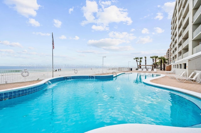 community pool with a patio and fence