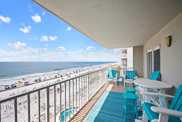 balcony with view of water and beach