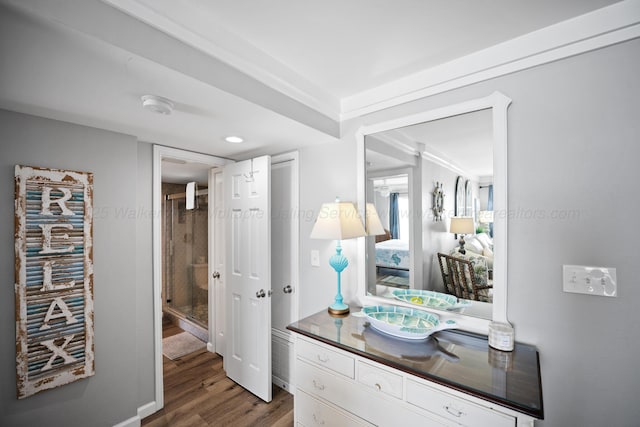 bathroom featuring wood finished floors, a stall shower, and vanity