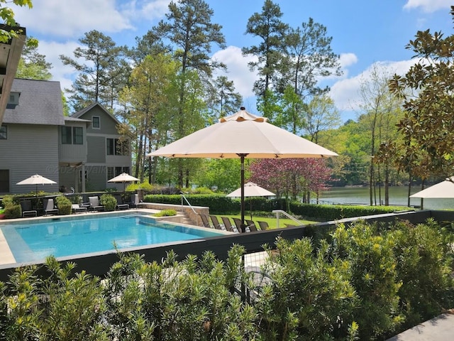 outdoor pool featuring a water view and a patio