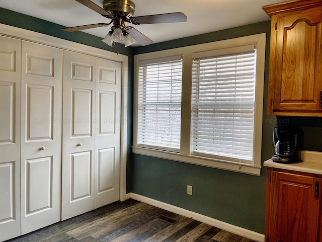 unfurnished bedroom with baseboards, a closet, ceiling fan, and dark wood finished floors