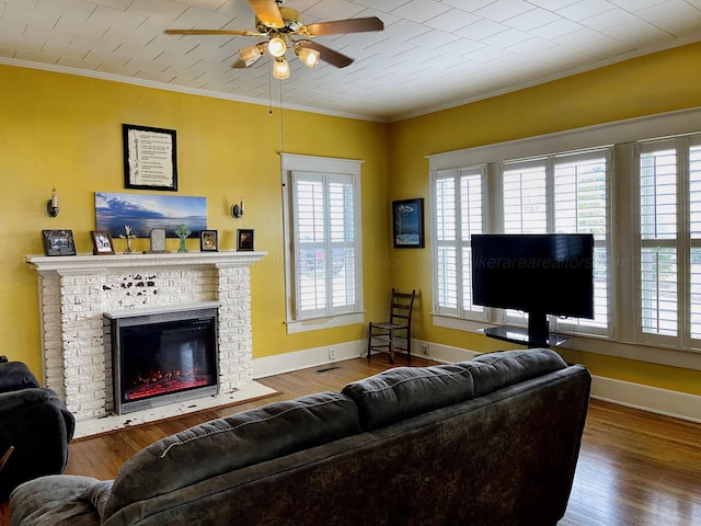 living room featuring baseboards, wood finished floors, ornamental molding, and a ceiling fan