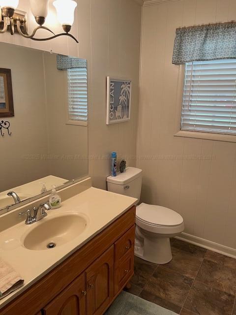 915 County Highway 4, Winfield, AL 35594 - bathroom featuring toilet, vanity, an inviting chandelier, and baseboards