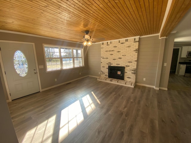 unfurnished living room with ceiling fan, wood finished floors, wood ceiling, and a brick fireplace