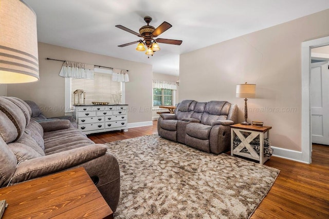 living room with dark wood-type flooring and ceiling fan