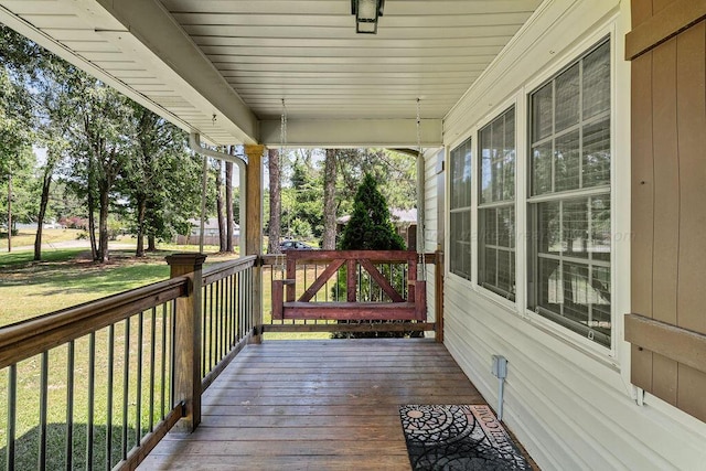 wooden terrace featuring a lawn