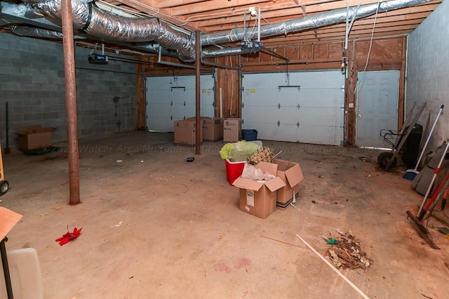 garage with a garage door opener and concrete block wall
