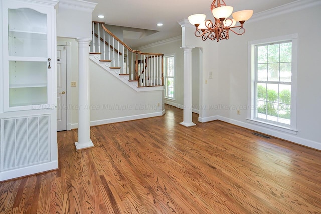interior space featuring visible vents, a healthy amount of sunlight, crown molding, and wood finished floors