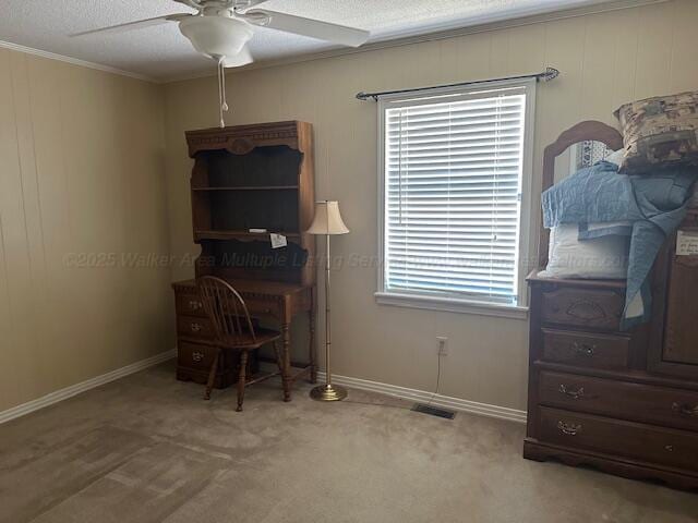 home office with carpet flooring, visible vents, crown molding, baseboards, and a ceiling fan