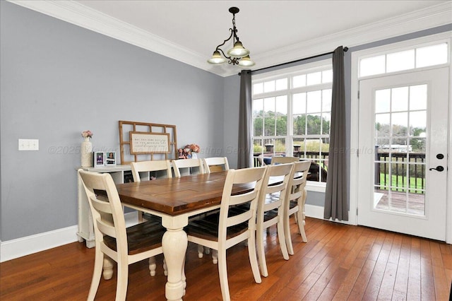dining space with ornamental molding, hardwood / wood-style flooring, and baseboards
