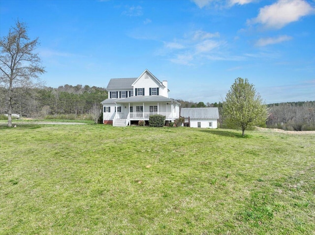 view of front facade with a front lawn, a chimney, and covered porch