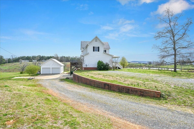 view of side of home with a lawn, an outbuilding, and a garage