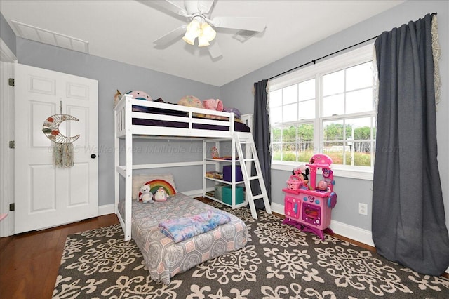 bedroom featuring baseboards, wood finished floors, and a ceiling fan