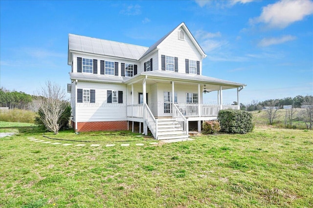 view of front facade with a front lawn, metal roof, and covered porch