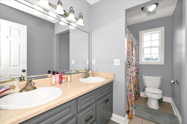 full bath featuring toilet, tile patterned flooring, a sink, and double vanity