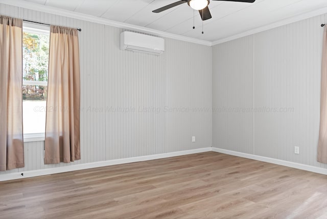 empty room featuring a wall mounted air conditioner, ceiling fan, ornamental molding, and light wood-style floors