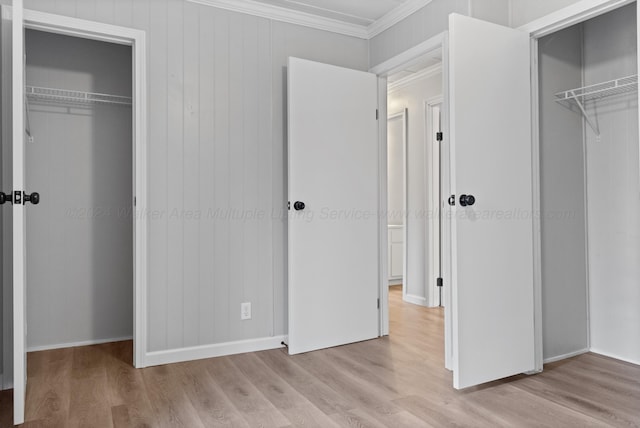 unfurnished bedroom with a closet, crown molding, and wood finished floors